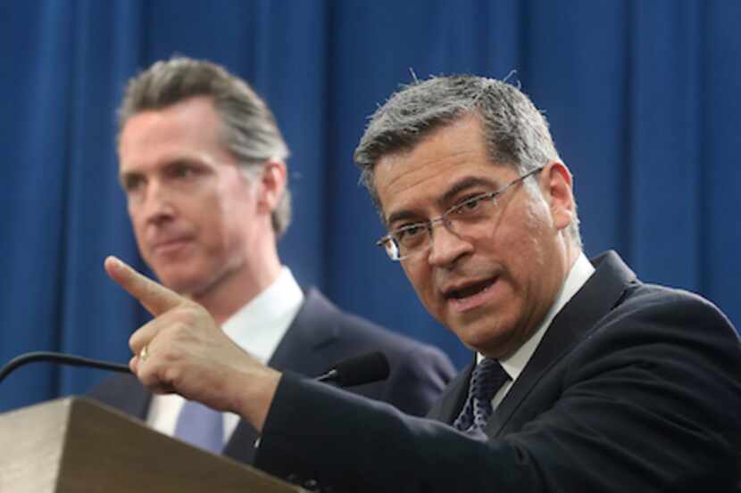 El procurador general de California Xavier Becerra, acompañado por el gobernador Gavin...