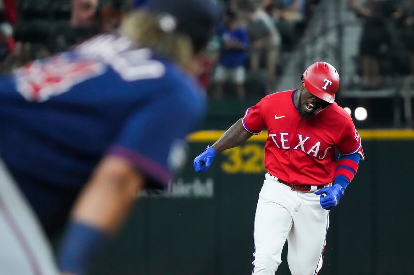 Texas Rangers center fielder Adolis Garcia celebrates as he rounds the bases after hitting a...