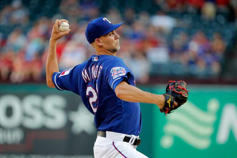 Texas Rangers' Mike Minor throws to a Minnesota Twins batter during the first inning of a...