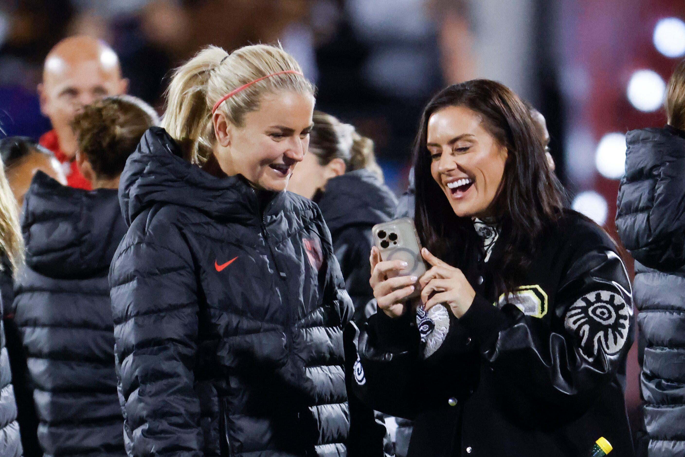 United States midfielder Lindsey Horan (left) talks to former soccer player Ali Krieger...