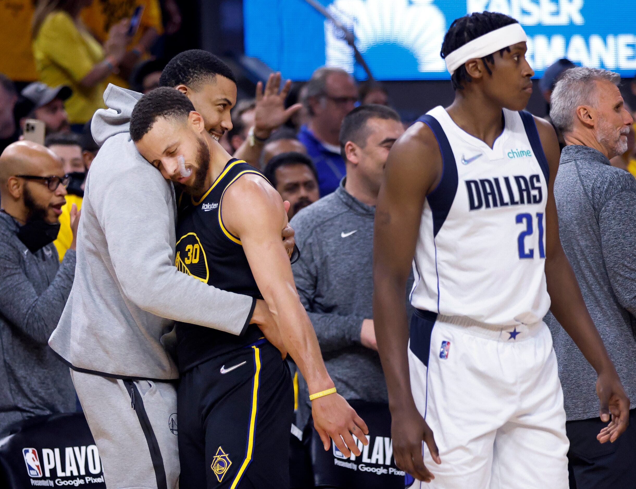 Golden State Warriors guard Stephen Curry (30) receives a hug from a teammate as he comes...