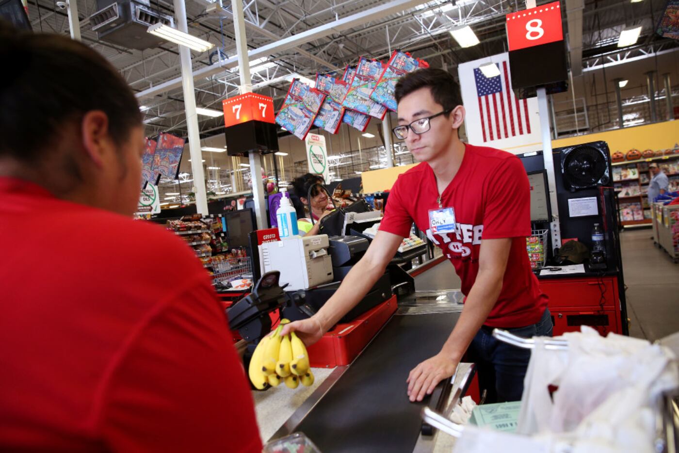 Orlando Delgado, a cashier from the H-E-B in Laredo, checks out customers at the grocery...