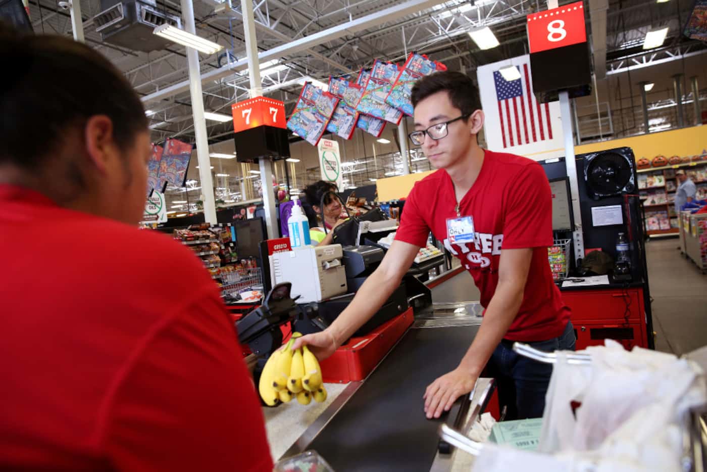 Orlando Delgado, a cashier from the H-E-B in Laredo, checks out customers at the grocery...