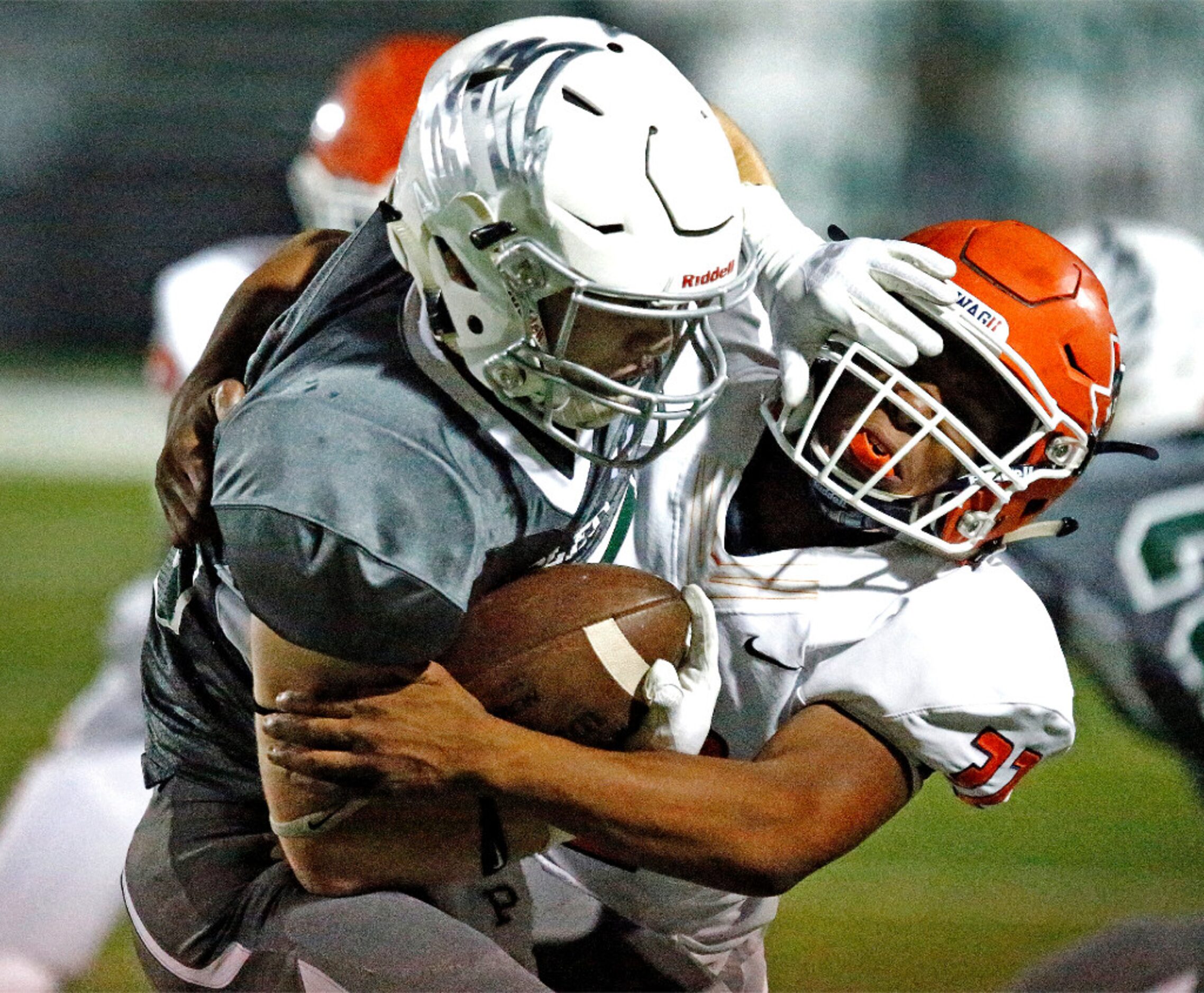 Prosper High School running back Cody Gallegos (25) gets a hand on the facemask of McKinney...