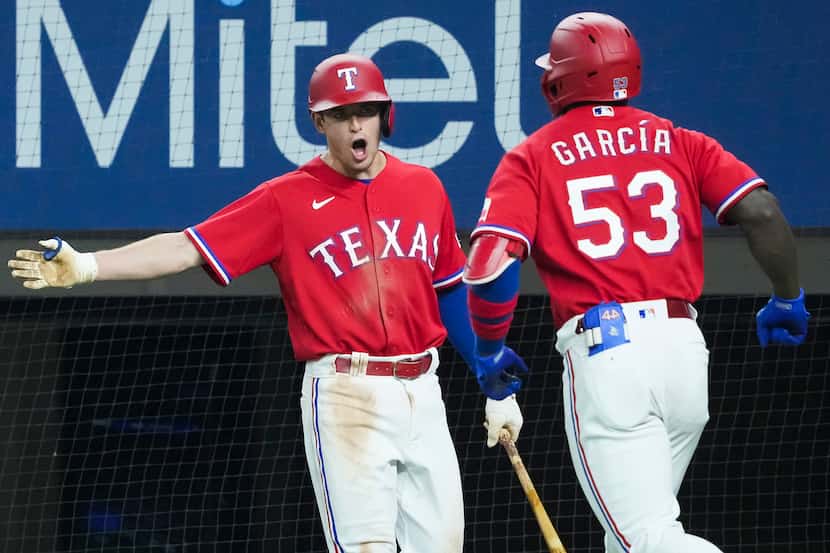 Texas Rangers center fielder Adolis Garcia celebrates second baseman Nick Solak after...