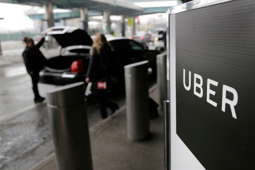 FILE - In this March 15, 2017, file photo, a sign marks a pick-up point for the Uber car...