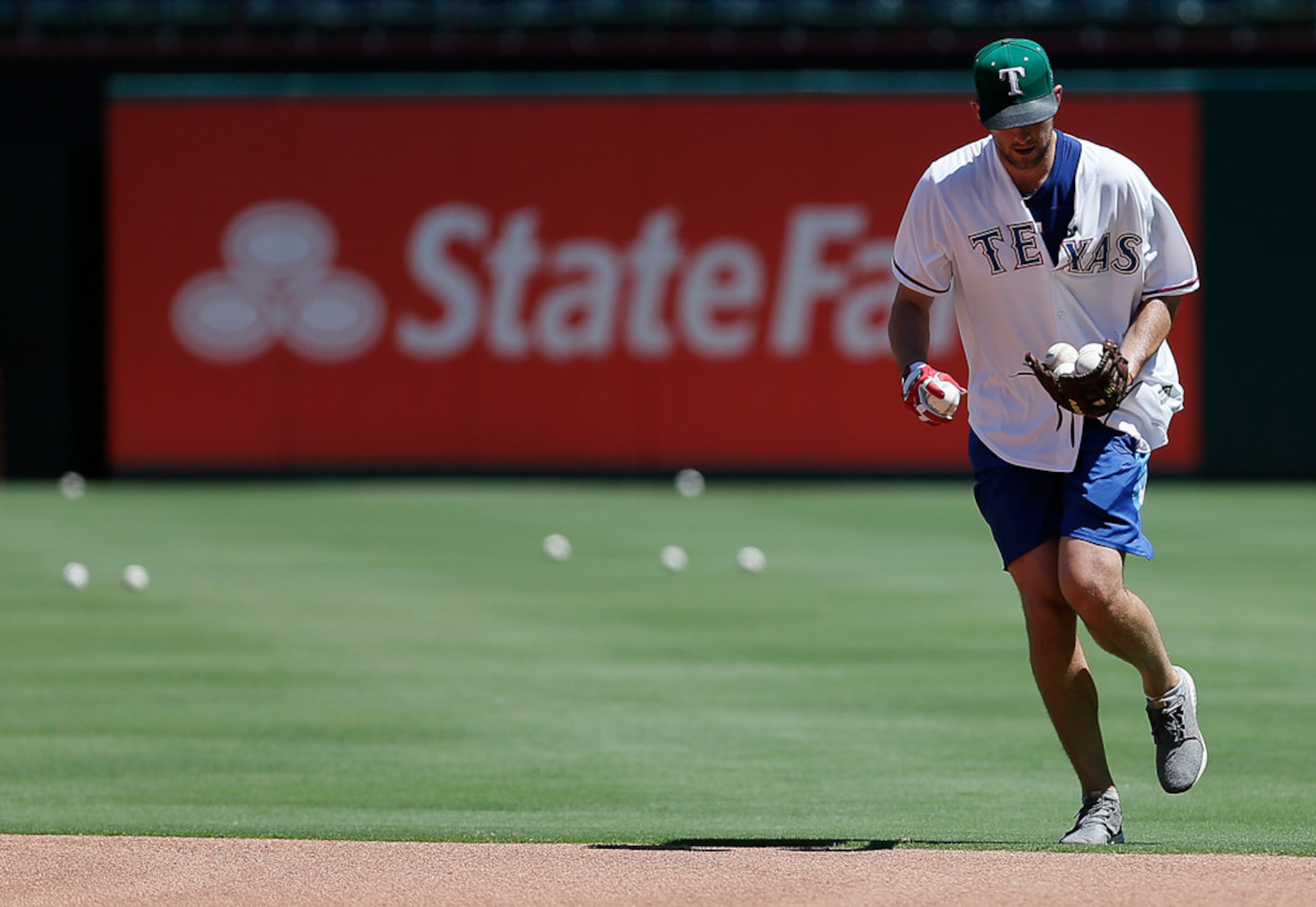 Dallas Stars goalie Ben Bishop collects baseballs from the outfield during a batting...