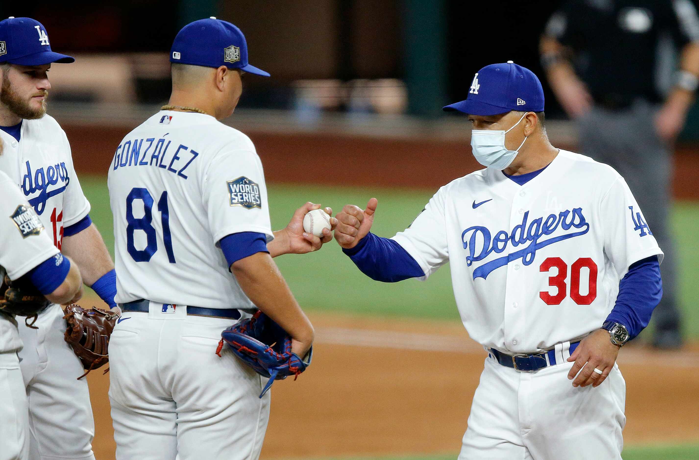 Los Angeles Dodgers manger Dave Roberts gives relief pitcher Victor Gonzalez (81) a fist...