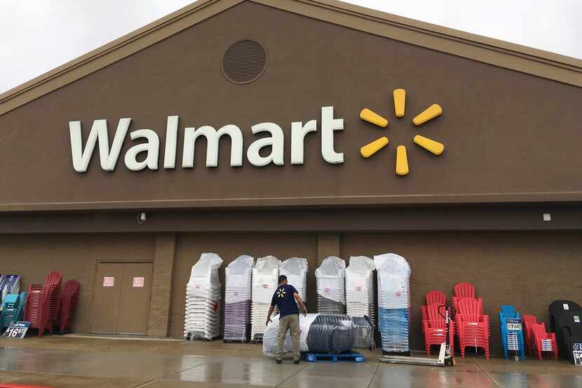 A worker stacks merchandise outside a Walmart in Salem, N.H. Walmart is boosting its...