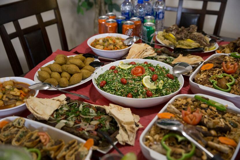 Middle Eastern dishes are set out at a housewarming party that Rania Alahmad and husband...