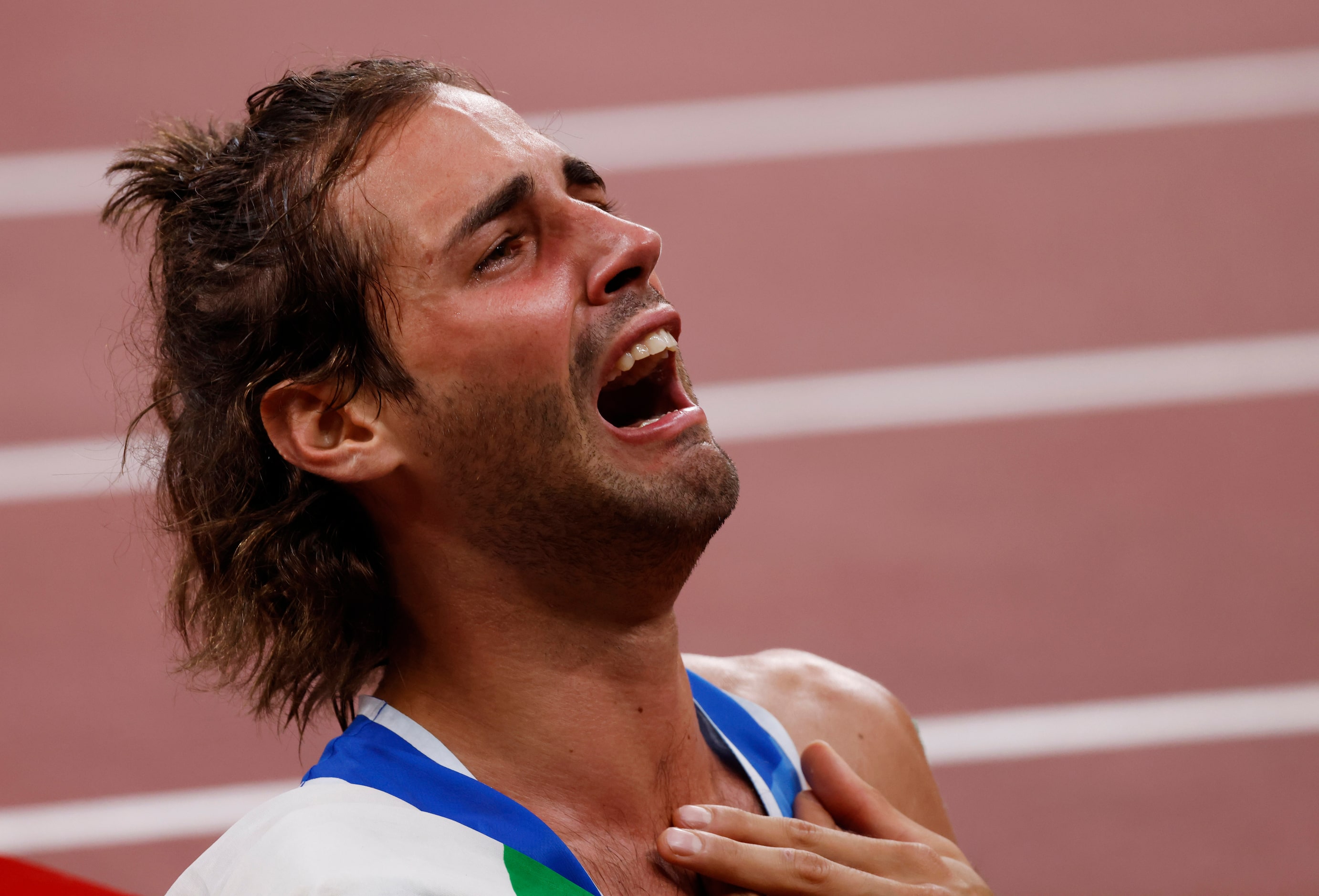 Italy’s Gianmarco Tamberi gets emotional after winning a gold medal in the men’s high jump...