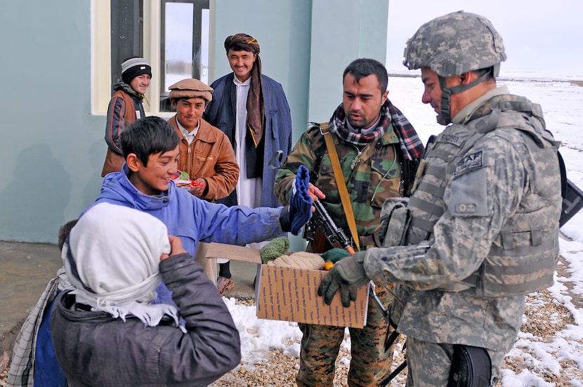 Outside of the newly built school, Troncoso holds one of the boxes with donated items from...