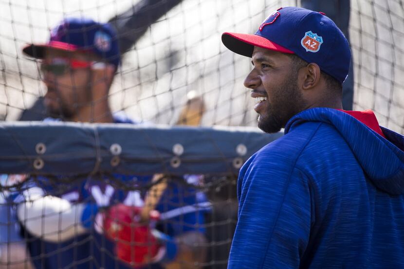 Texas Rangers shortstop Elvis Andrus watches as outfielder Ian Desmond takes batting...