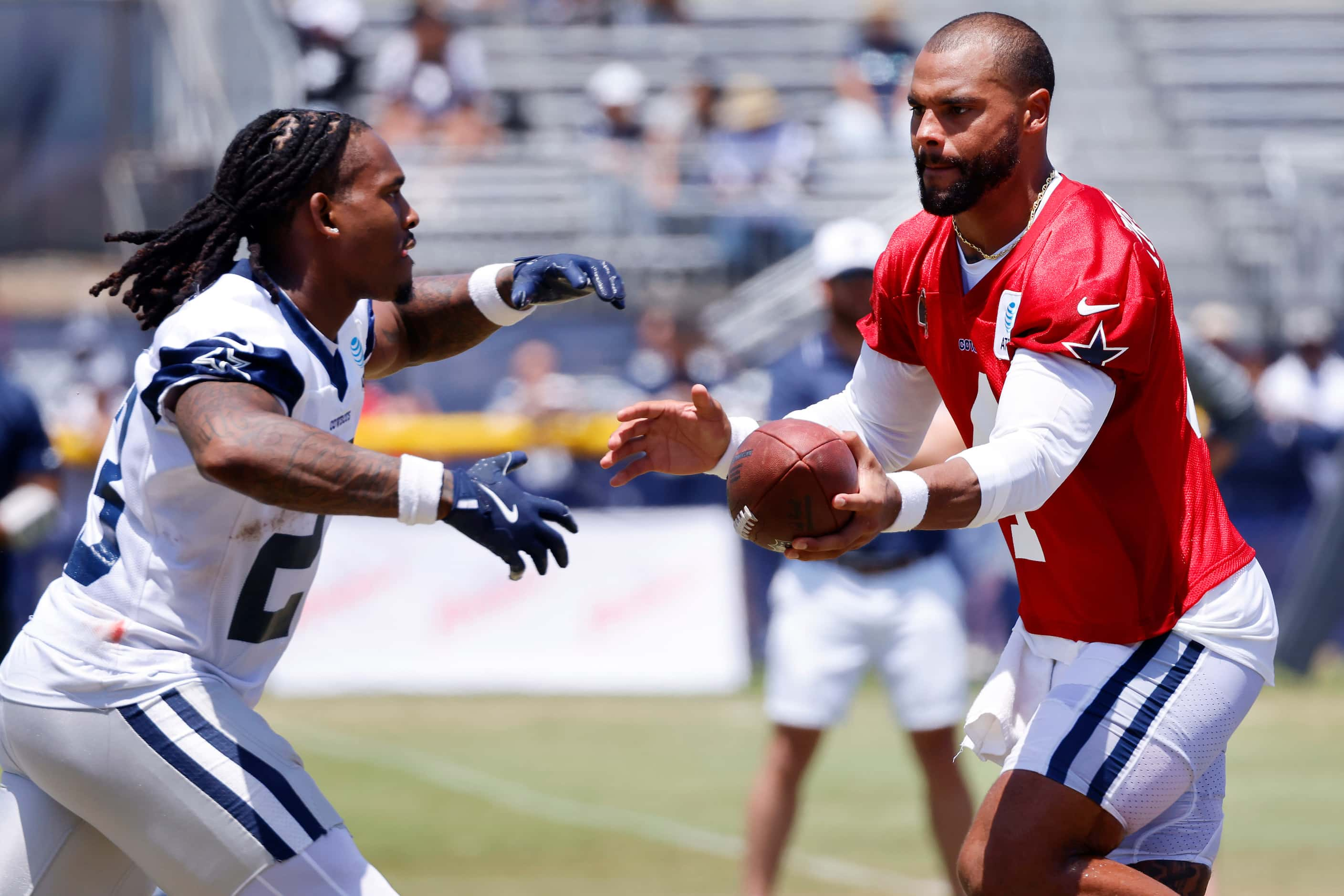 Dallas Cowboys quarterback Dak Prescott (4) fakes the handoff to running back Rico Dowdle...