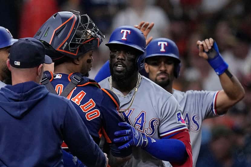 Houston Astros catcher Martin Maldonado and Texas Rangers' Adolis Garcia argue as the...