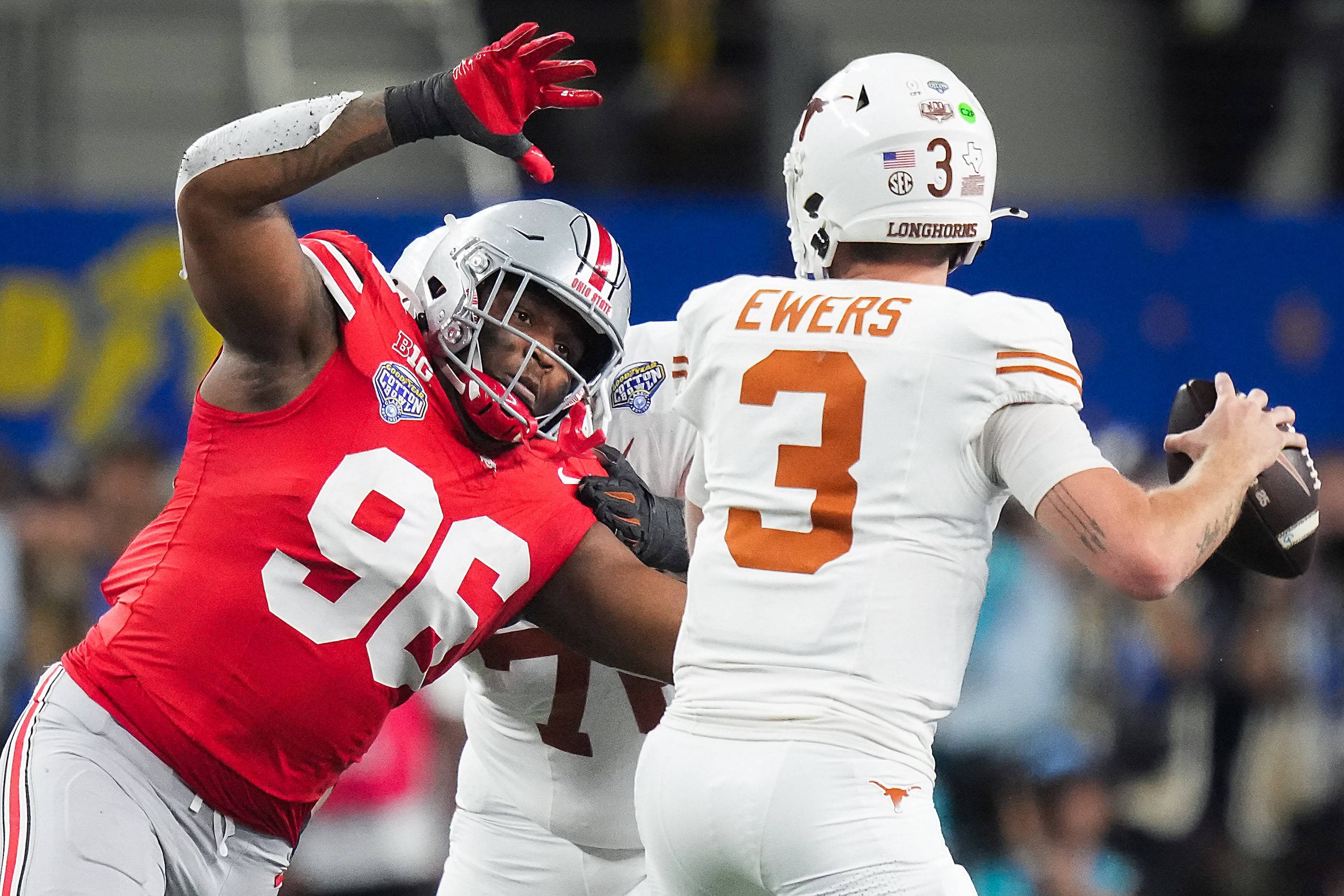 Texas quarterback Quinn Ewers (3) throws a pass under pressure from Ohio State defensive end...