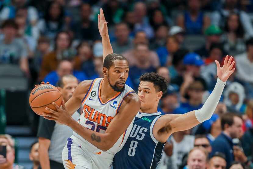 Phoenix Suns forward Kevin Durant, left, posts up against Dallas Mavericks guard Josh Green...