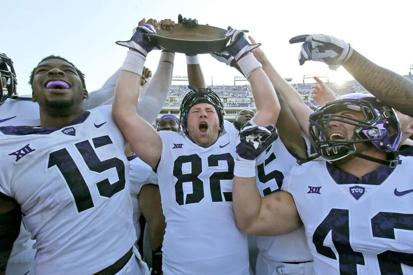 TCU tight end Charlie Reid (82) holds up the Iron Skillet with teammates Ben Banogu (15) and...