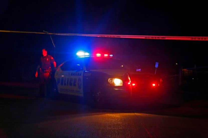 
A Dallas police officer blocked a road near the scene of two shootings Thursday on Veterans...