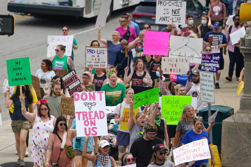 Abortion-rights protestors march between the Indiana Statehouse and the Indiana State...