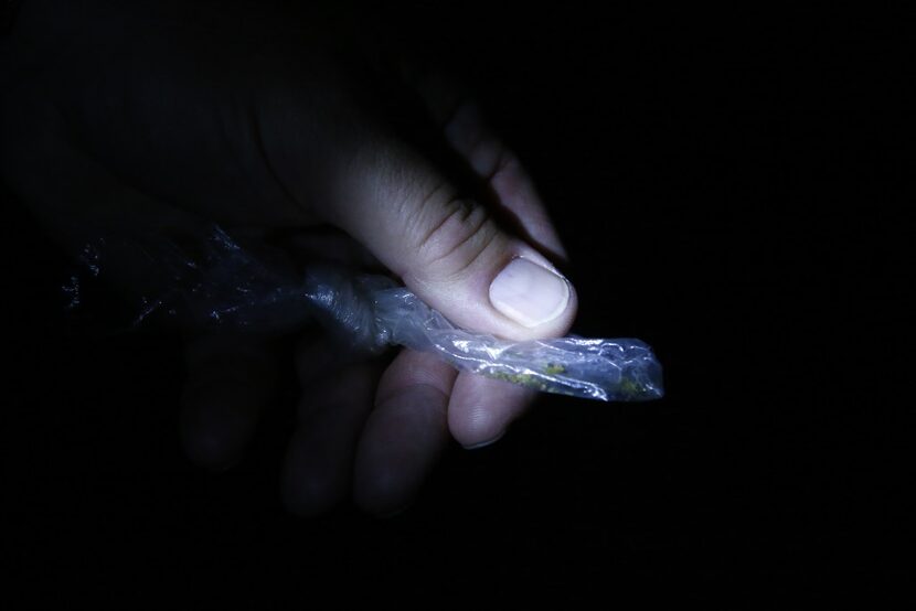 Officer Stephen Burres III holds a bag of marijuana that he confiscated with a warning...