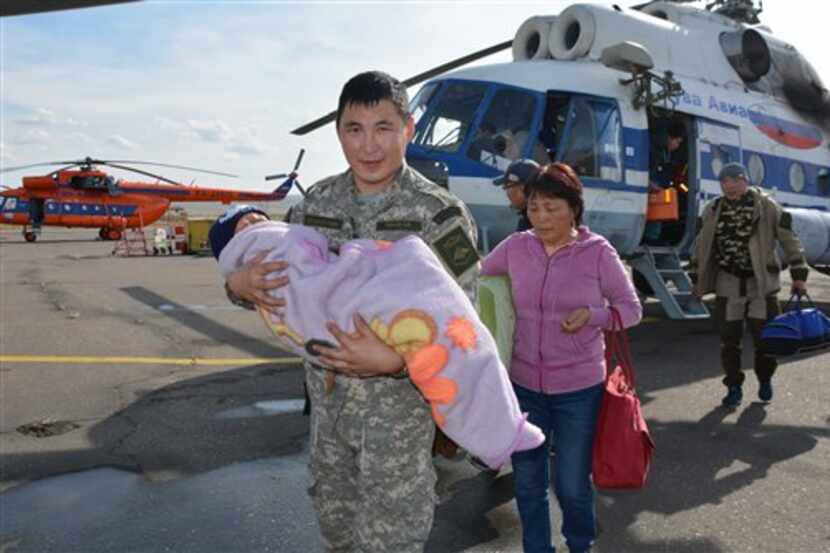 Un soldado carga un niño que pasó tres días perdido en un bosque siberiano. /AP
