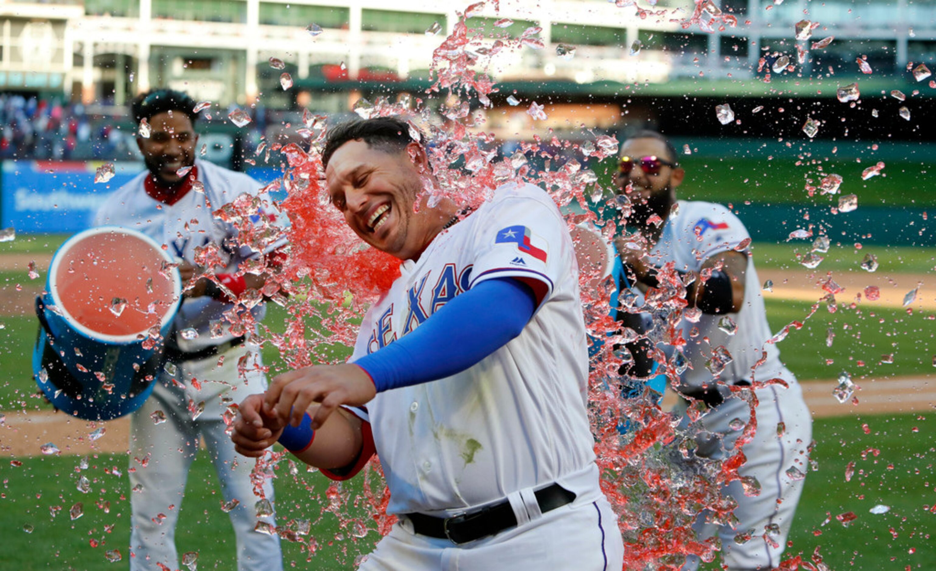 Texas Rangers Asdrubal Cabrera, center, is doused with drink coolers by teammates Elvis...