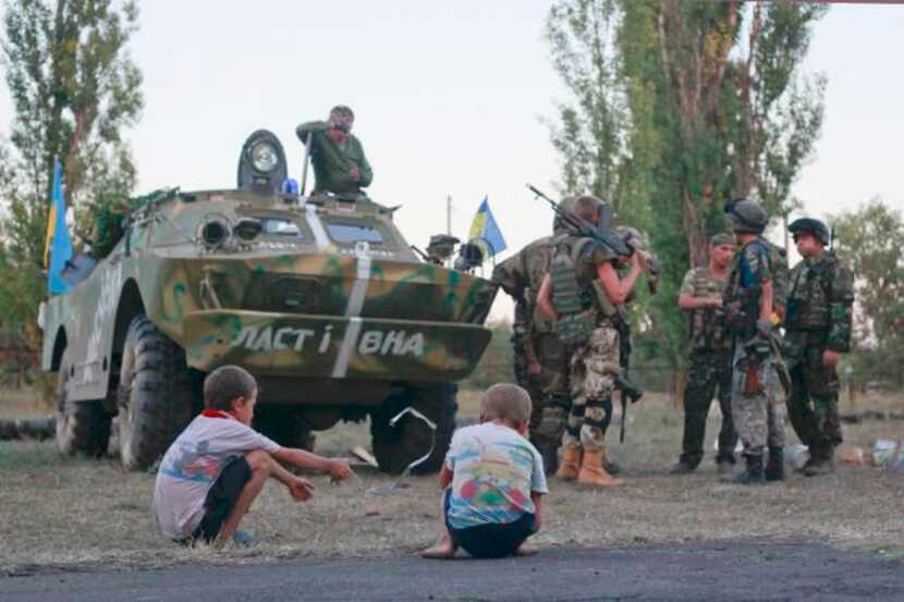 
Children played near Ukrainian soldiers in Shchastya on Wednesday, while Russia’s Vladimir...