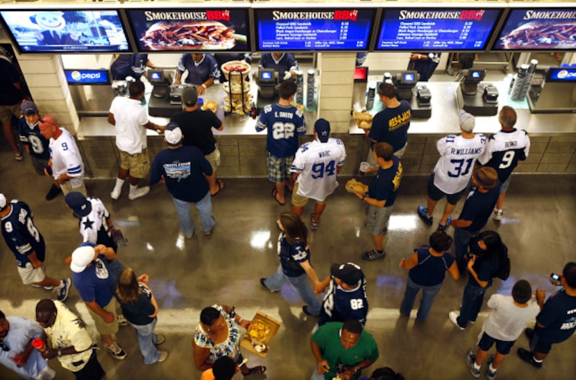 Cowboys fans mingled around one of the concession stands on the main concourse during a...