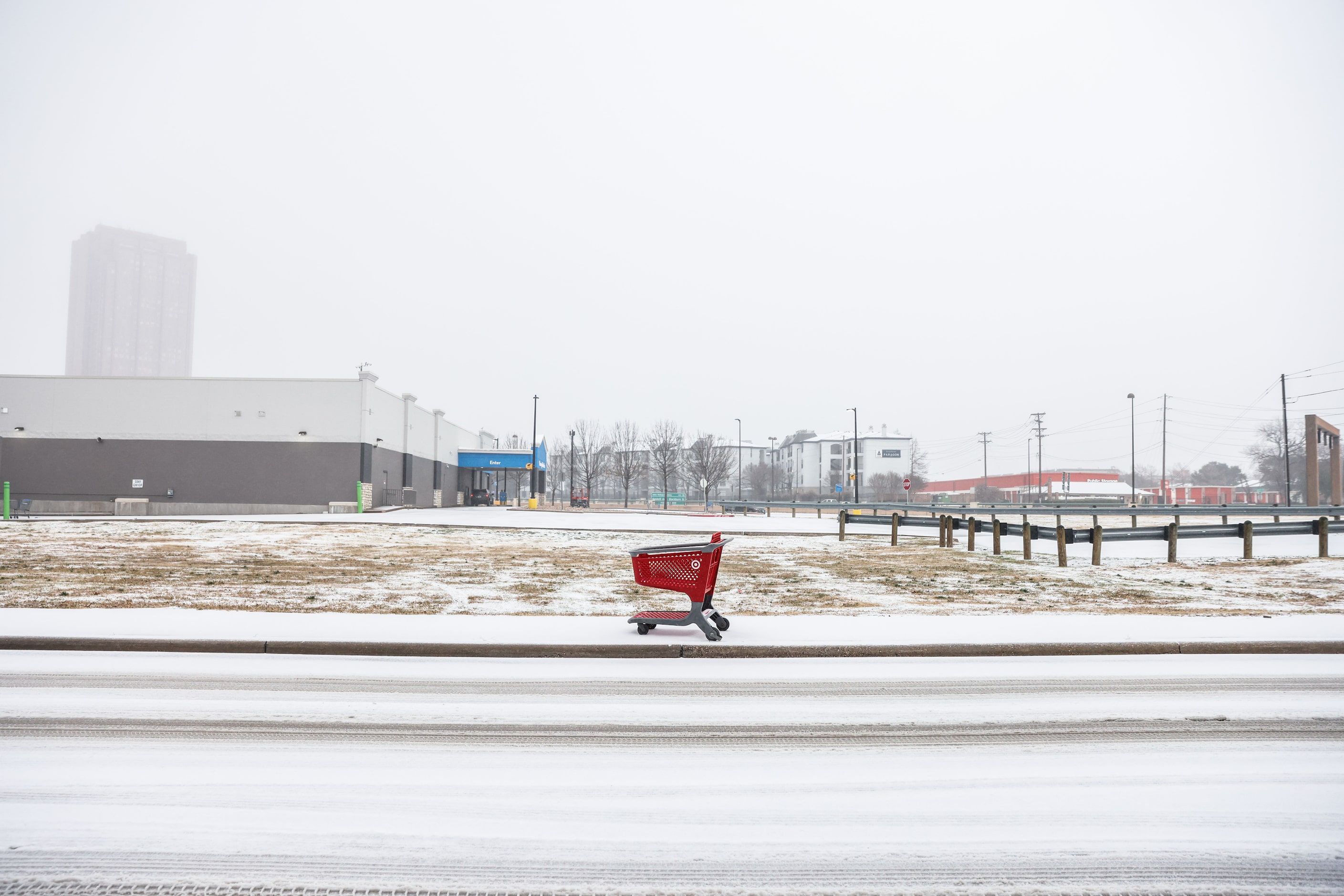 A Target shopping cart lies on the sideway at N Hall St as sleet falls over the Dallas...