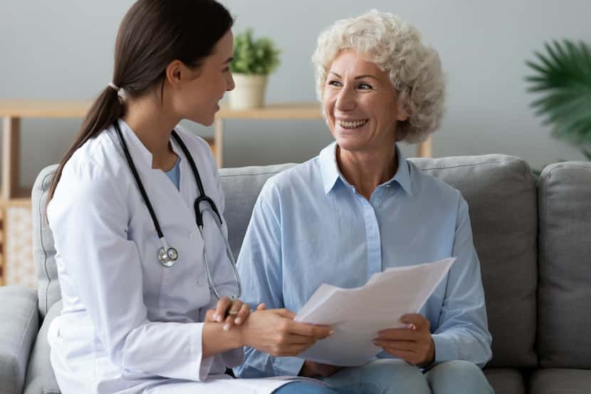 Doctor consults with an elderly patient on a couch.