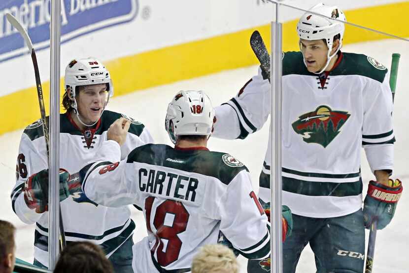Minnesota Wild left wing Erik Haula (56) is congratulated by center Ryan Carter (18) and...