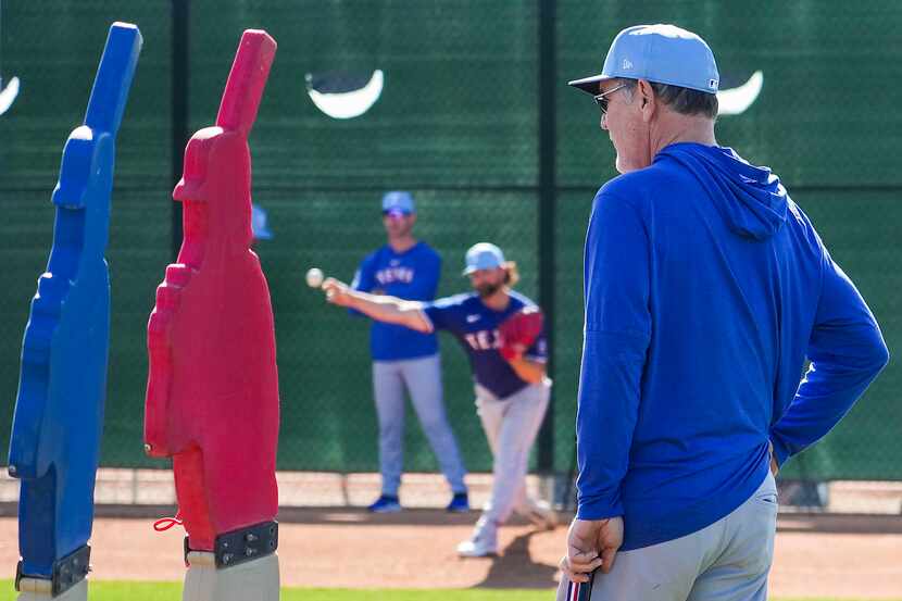 Texas Rangers manager Bruce Bochy watches pitcher Kirby Yates throw in the bullpen during a...