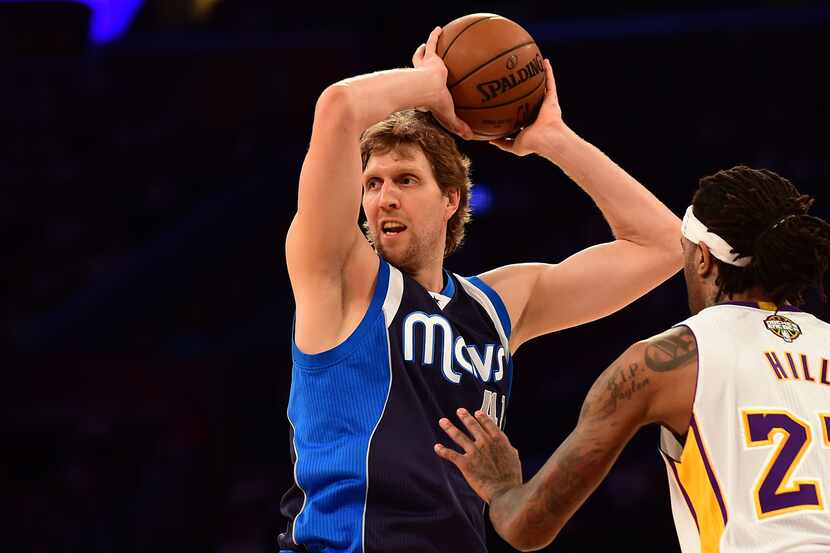 Dirk Nowitzki of the Dallas Mavericks looks to pass under pressure from Jordan Hill of the...