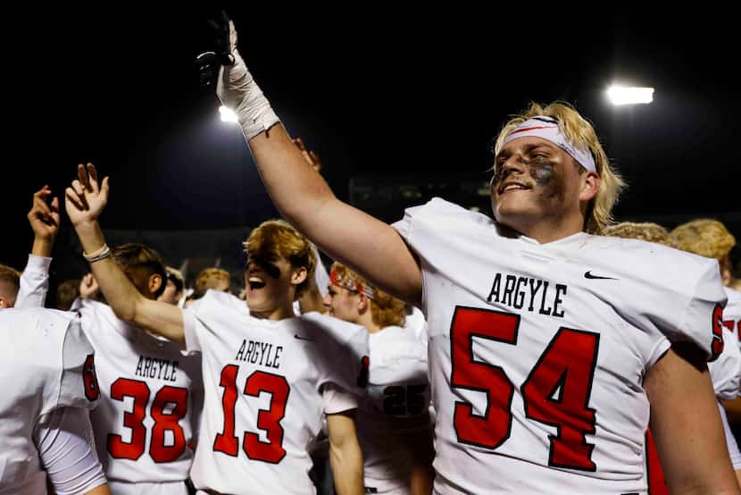 Argyle high players including Wes Tucker (54) celebrate after winning against Grapevine High...
