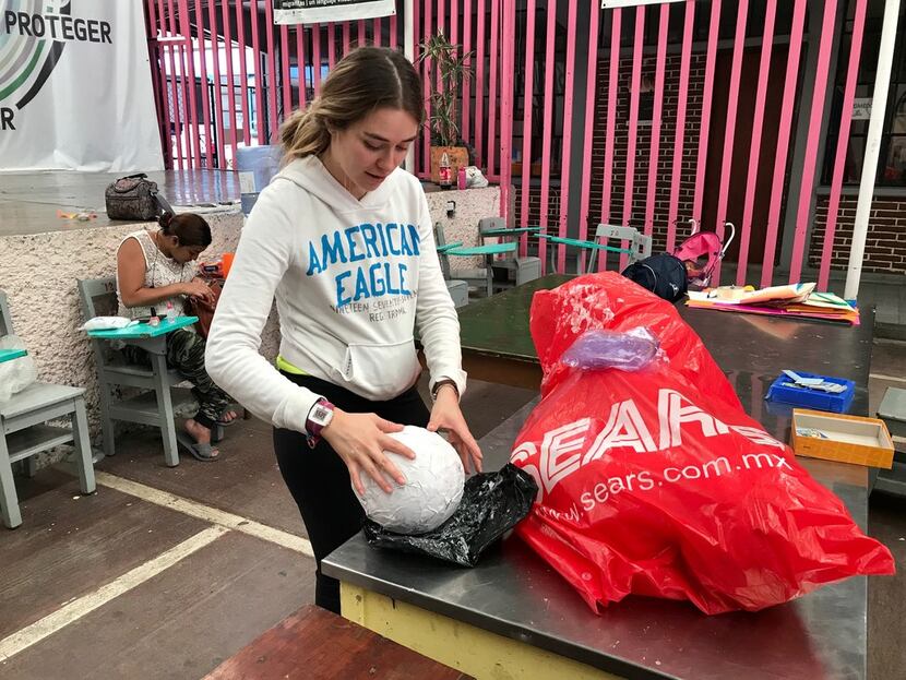Isabella Mariel, a volunteer at the Casamin shelter in Mexico City, teaches migrants basic...