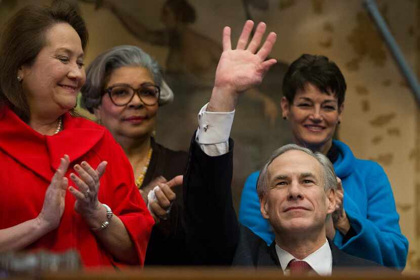 Gov. Greg Abbott, with wife Cecilia at left, waved to lawmakers before giving his state of...