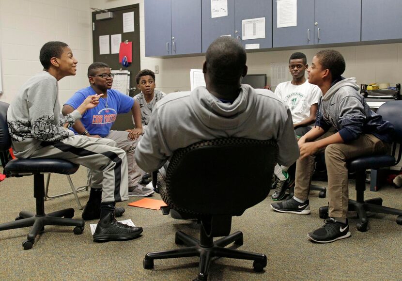 
Cobb Middle School coach Lamont Finley poses questions about African-American inventors,...