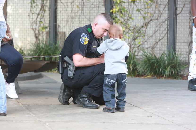 DART Officer Elmar Cannon interacts with a boy during a patrol in 2015 near the West End...