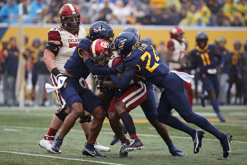Oklahoma running back Eric Gray (0) is defended by West Virginia safety Marcis Floyd (24)...