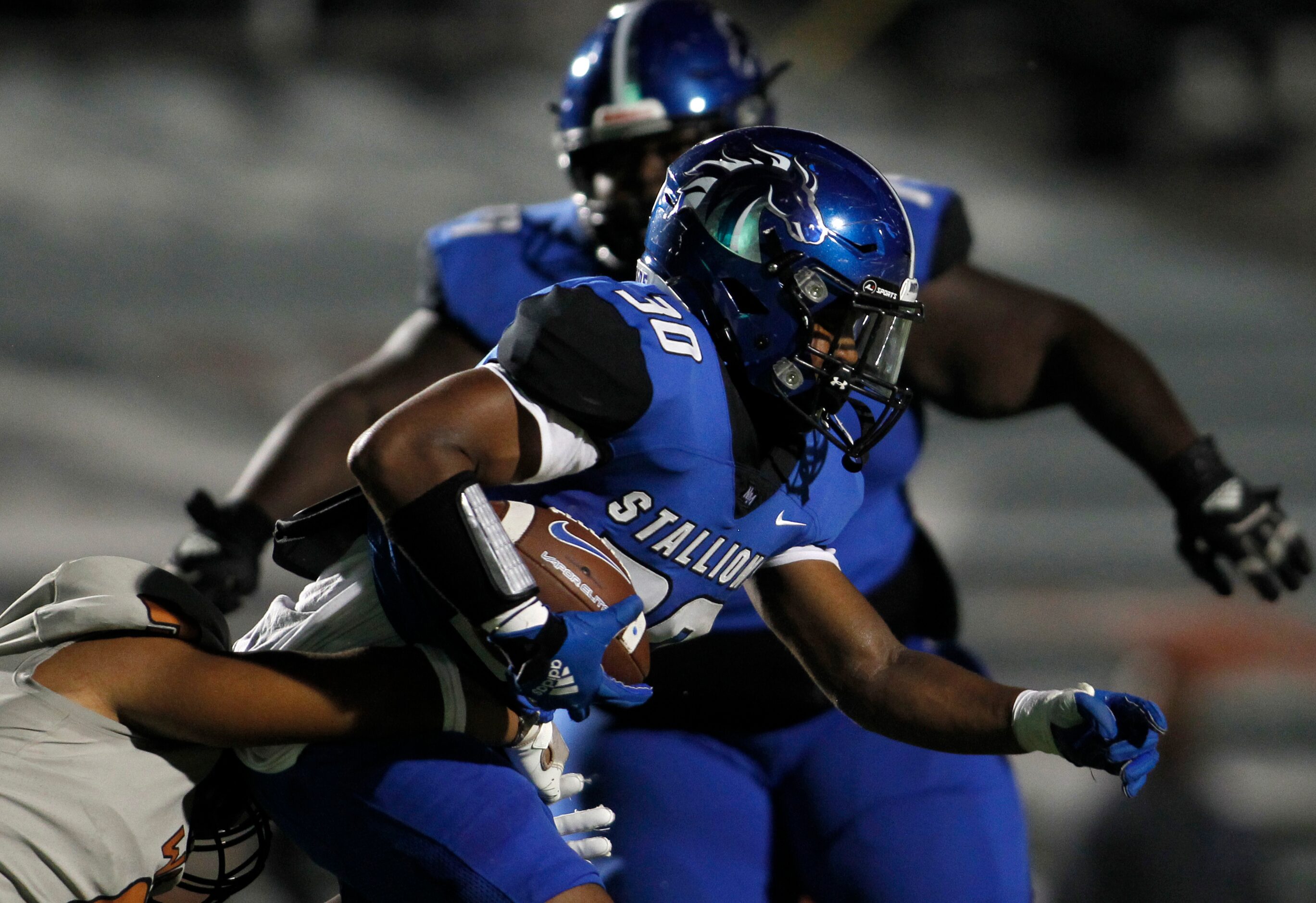 North Mesquite running back Michael Gibson (30) is tackled by a West Mesquite defender...