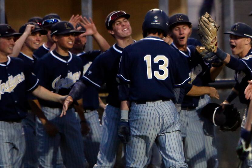 Keller's Will Lance (13) receives congratulations from teammates after his bases loaded hit...