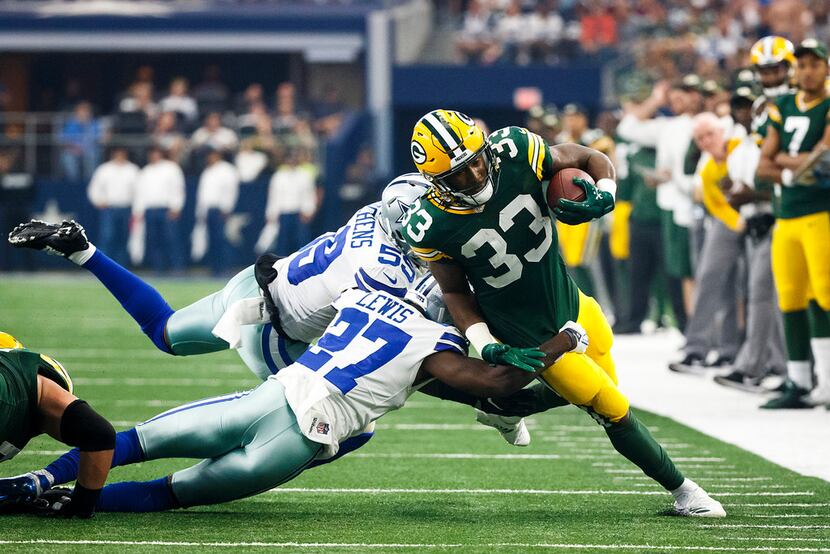 Green Bay Packers running back Aaron Jones (33) is brought down by Dallas Cowboys cornerback...