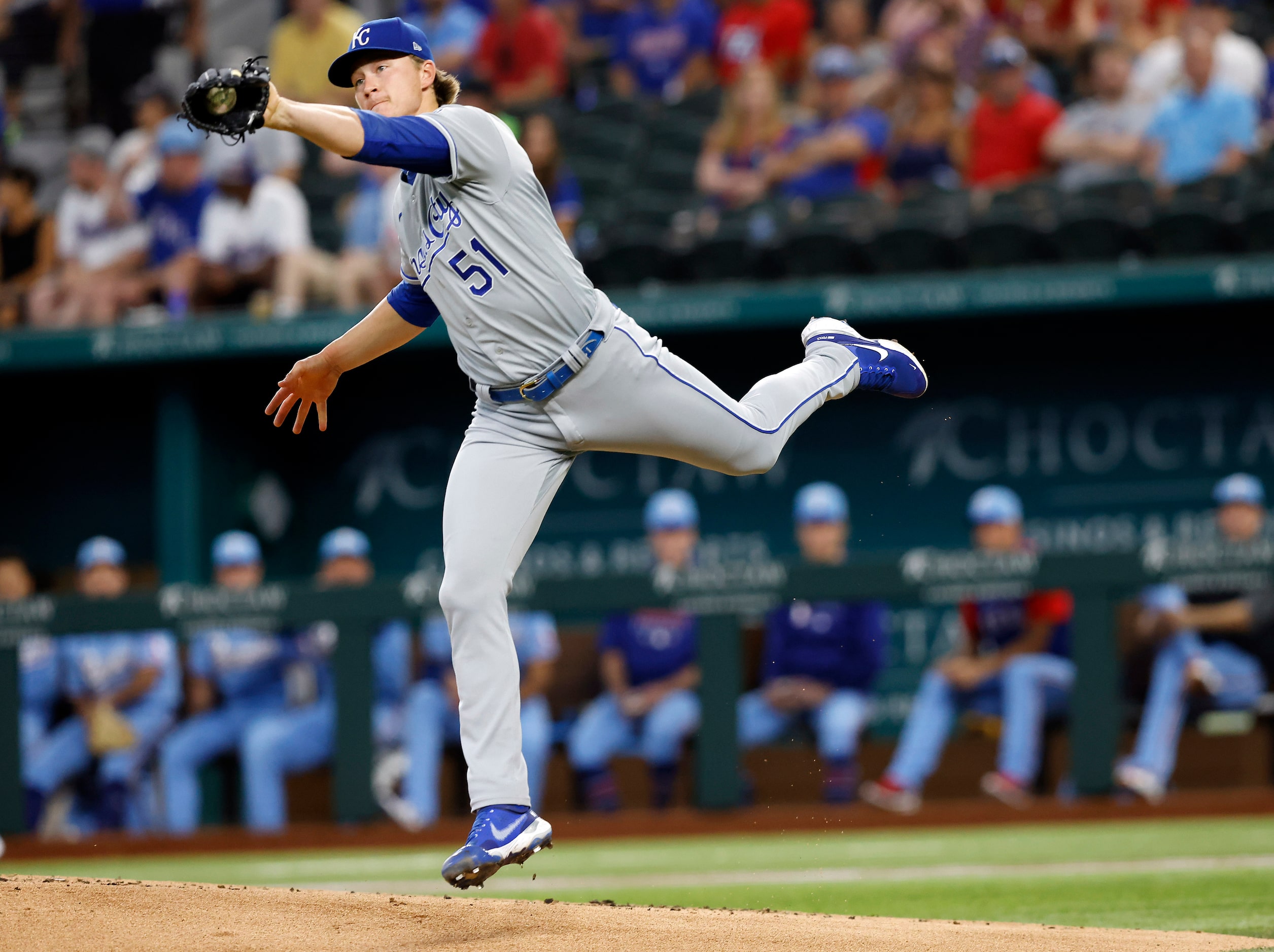 Kansas City Royals starting pitcher Brady Singer (51) fields a hard hit ball back to the...