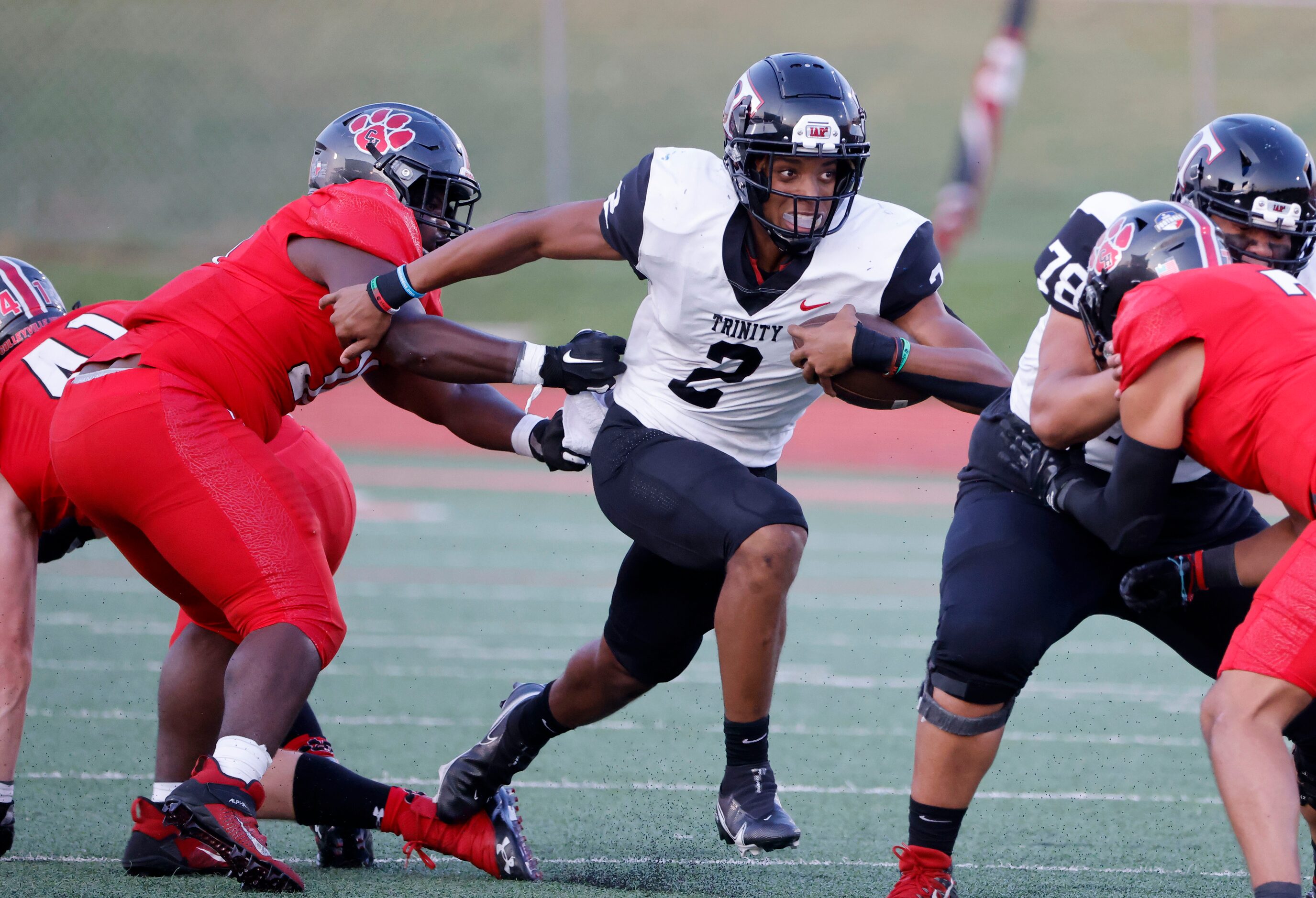 Colleyville defender Elijah Omar (left) tries to stop Euless Trinity quarterback Ollie...