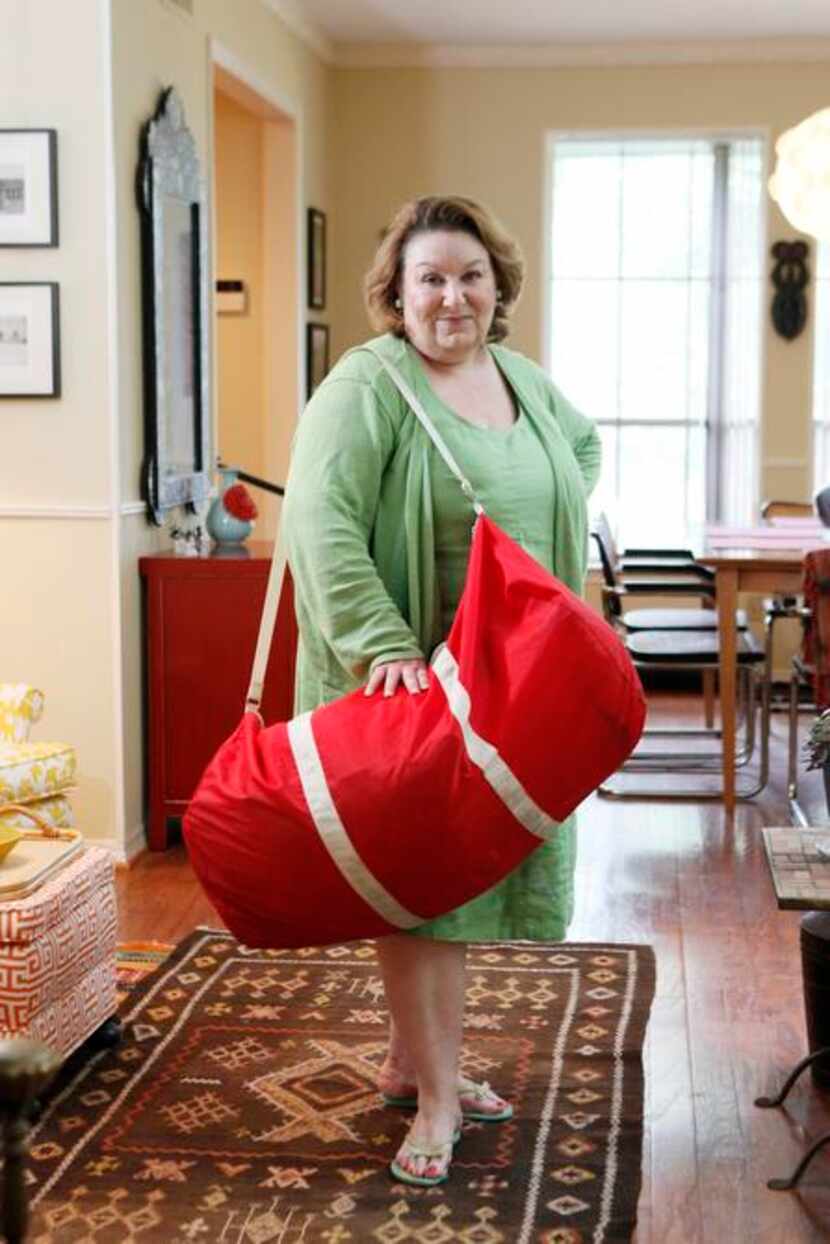 
Sheila Brenner with "big red," a large tote bag she uses while traveling to collect items...