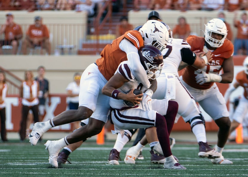 Mississippi State quarterback Michael Van Buren, right, gets sacked by Texas edge defender...