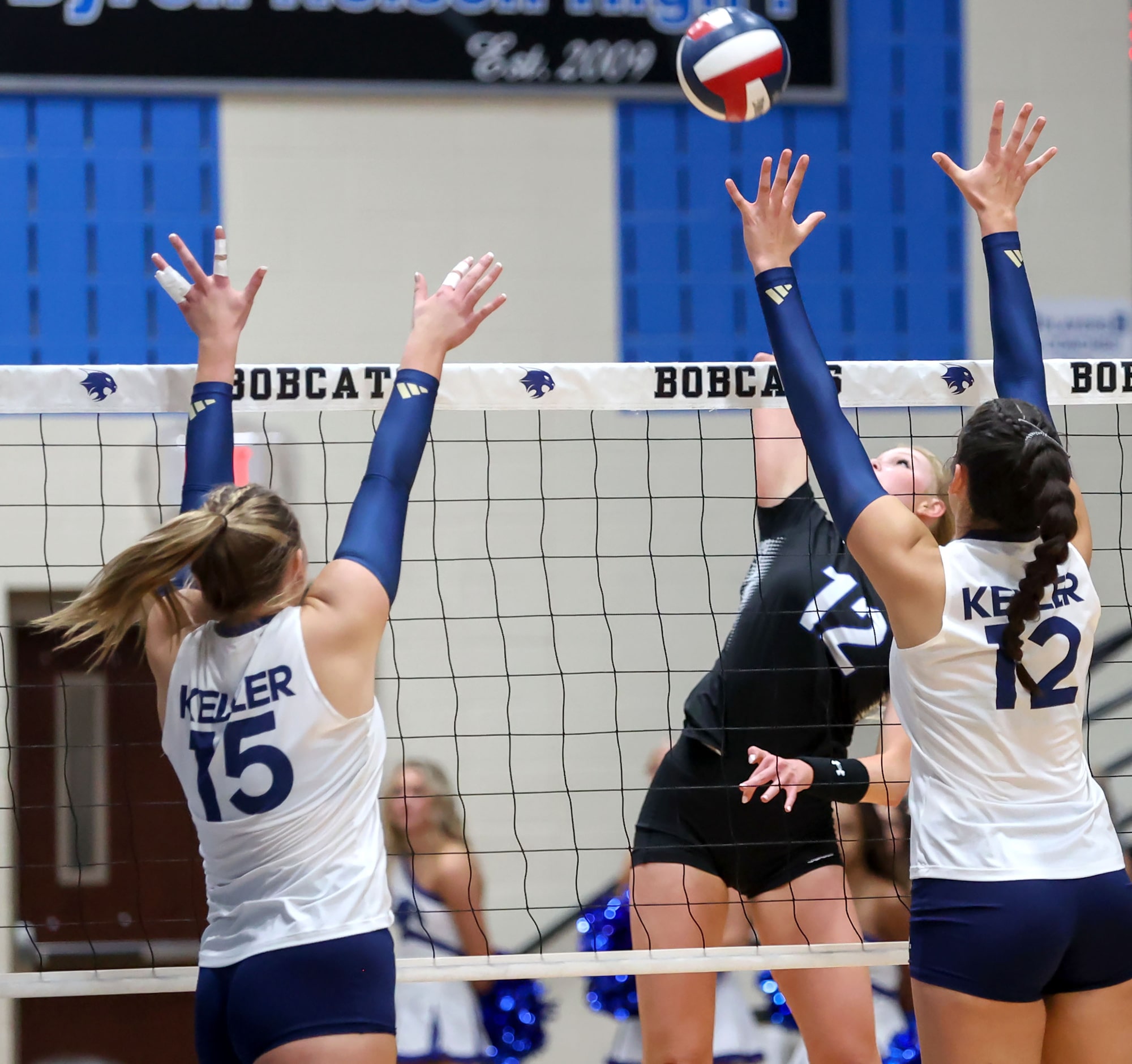 Byron Nelson's Ashlyn Seay (12) goes for a kill against Keller's Annabelle Nicher (15) and...