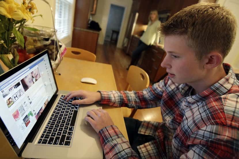 In this Oct. 24, 2013 photo, Mark Risinger, 16, checks his Facebook page on his computer as...