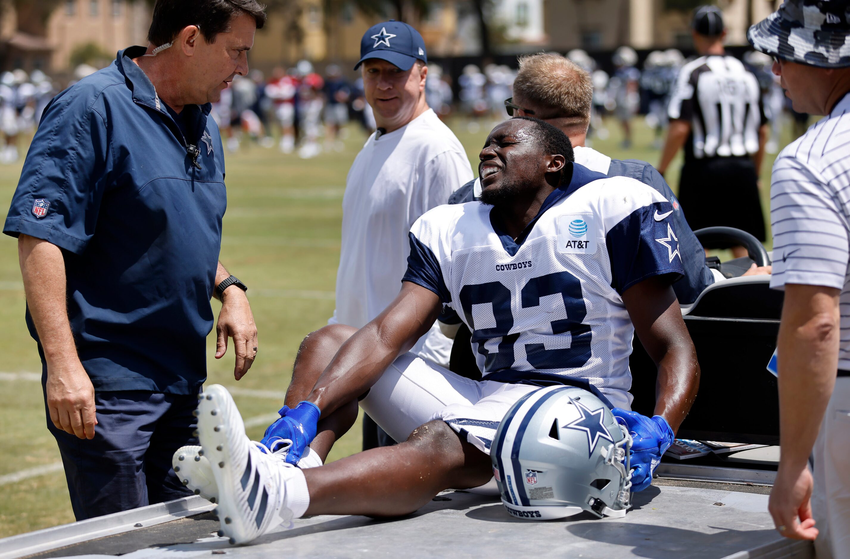 Dallas Cowboys wide receiver James Washington (83) holds his right foot as he is carted off...